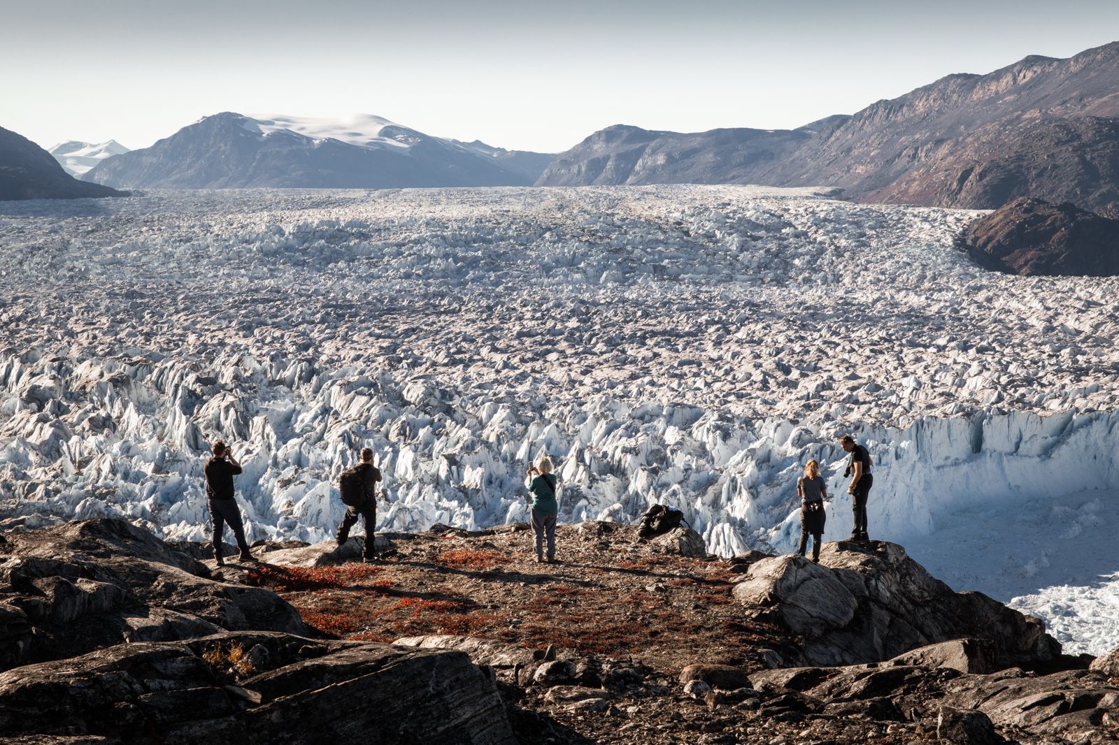 A small group facing a glacier in Greenland